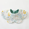 A white cotton baby feeding bib with a green interior and a floral pattern of yellow and blue flowers.