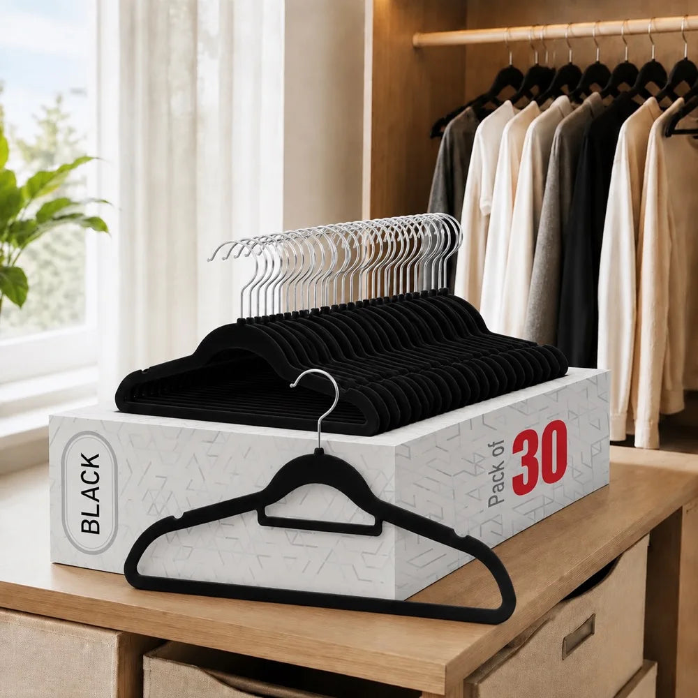 A box of black velvet non-slip hangers with 360 degree rotating hooks displayed on a wooden surface.