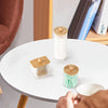 A set of three wooden and glass cotton swabs and a bathroom organizer displayed on a white table.