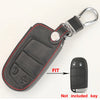 A black leather replacement key fob shell with a silver split ring attached, shown next to the actual key.