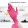 A hand wearing a pink rose red nitrile glove is shown against a blurred kitchen background.