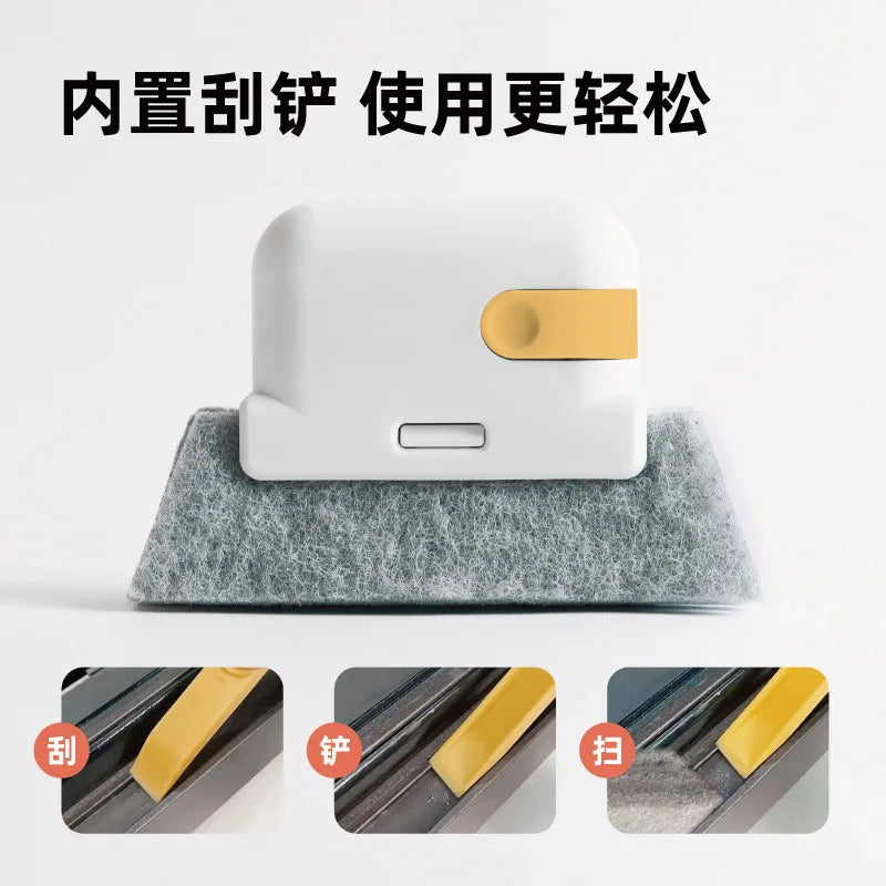 A white cleaning brush with a yellow scouring pad resting on a gray foam surface.