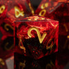 A close-up of a red resin polyhedral die with gold numbers, reflecting on a dark surface.