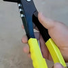 A hand holds a black and yellow heavy-duty pop rivet gun kit with a rivet and tool.