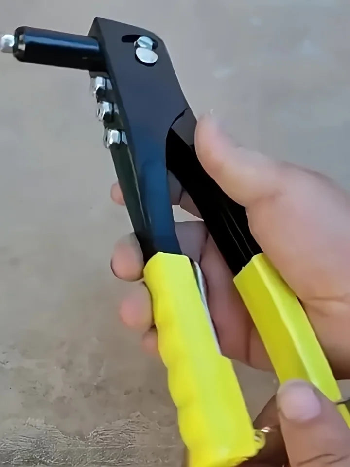 A hand holds a black and yellow heavy-duty pop rivet gun kit with a rivet and tool.