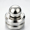 A polished silver kinetic metal desk spinner with a smooth spherical top and stacked rings.