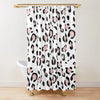 A white shower curtain featuring a black and pink leopard print pattern hanging from a gold rod.