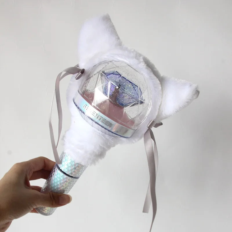 A hand holds a plush white cat-shaped cover for a SEVENTEEN official light stick.