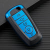 A blue TPU leather car key cover with four buttons is shown on a dark surface.