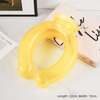 A yellow U-shaped reusable neck wrap is displayed on a white surface next to a book.