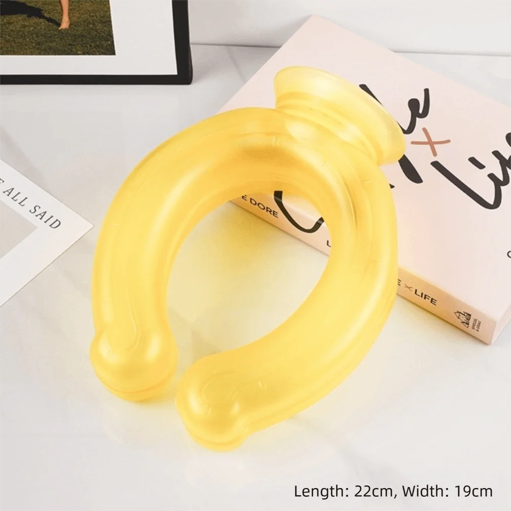 A yellow U-shaped reusable neck wrap is displayed on a white surface next to a book.