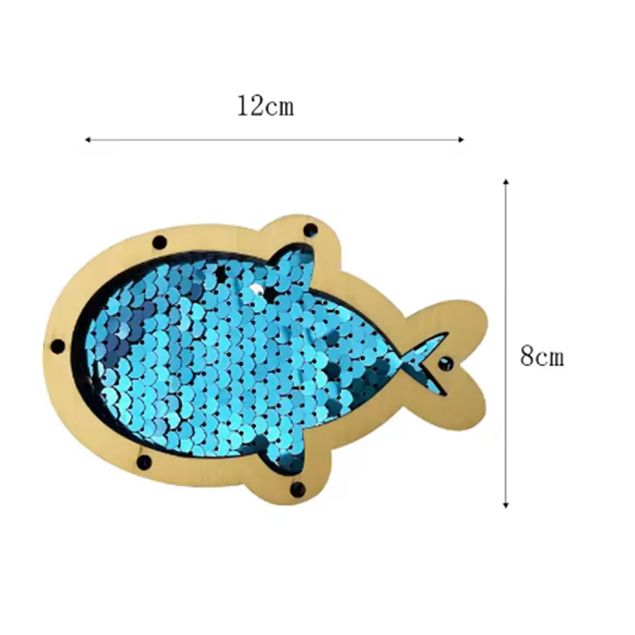 A wooden fish-shaped Montessori busy board with iridescent blue sequins.