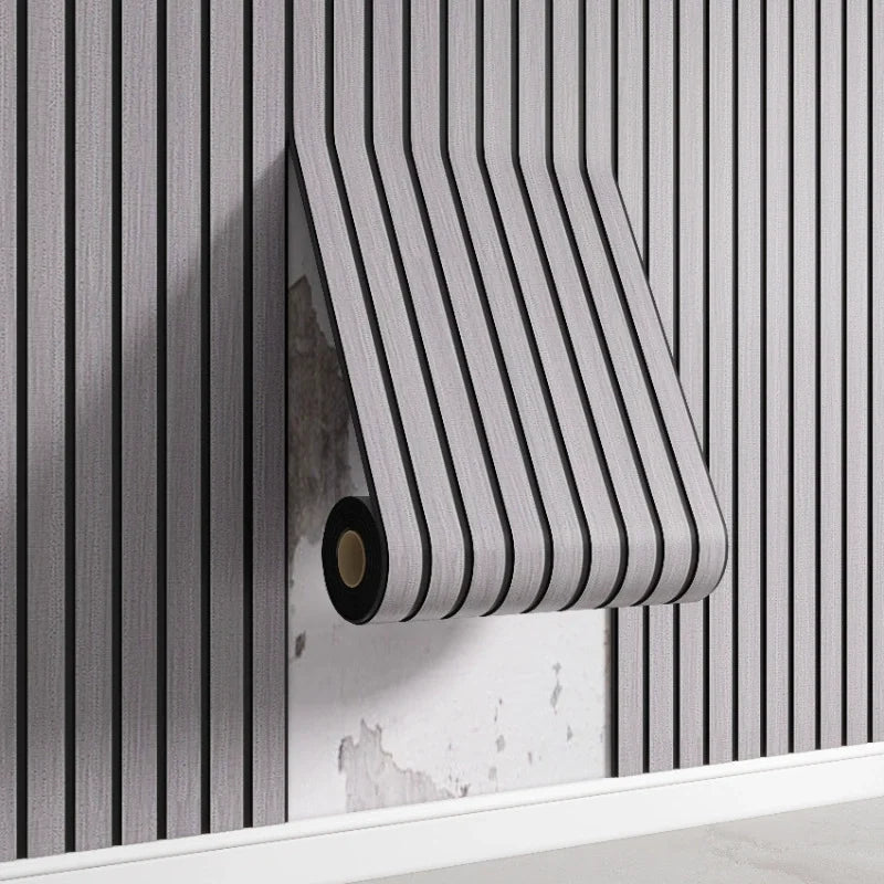 A roll of striped wood-look peel-and-stick wall panels is being installed on a vertical gray slat wall.