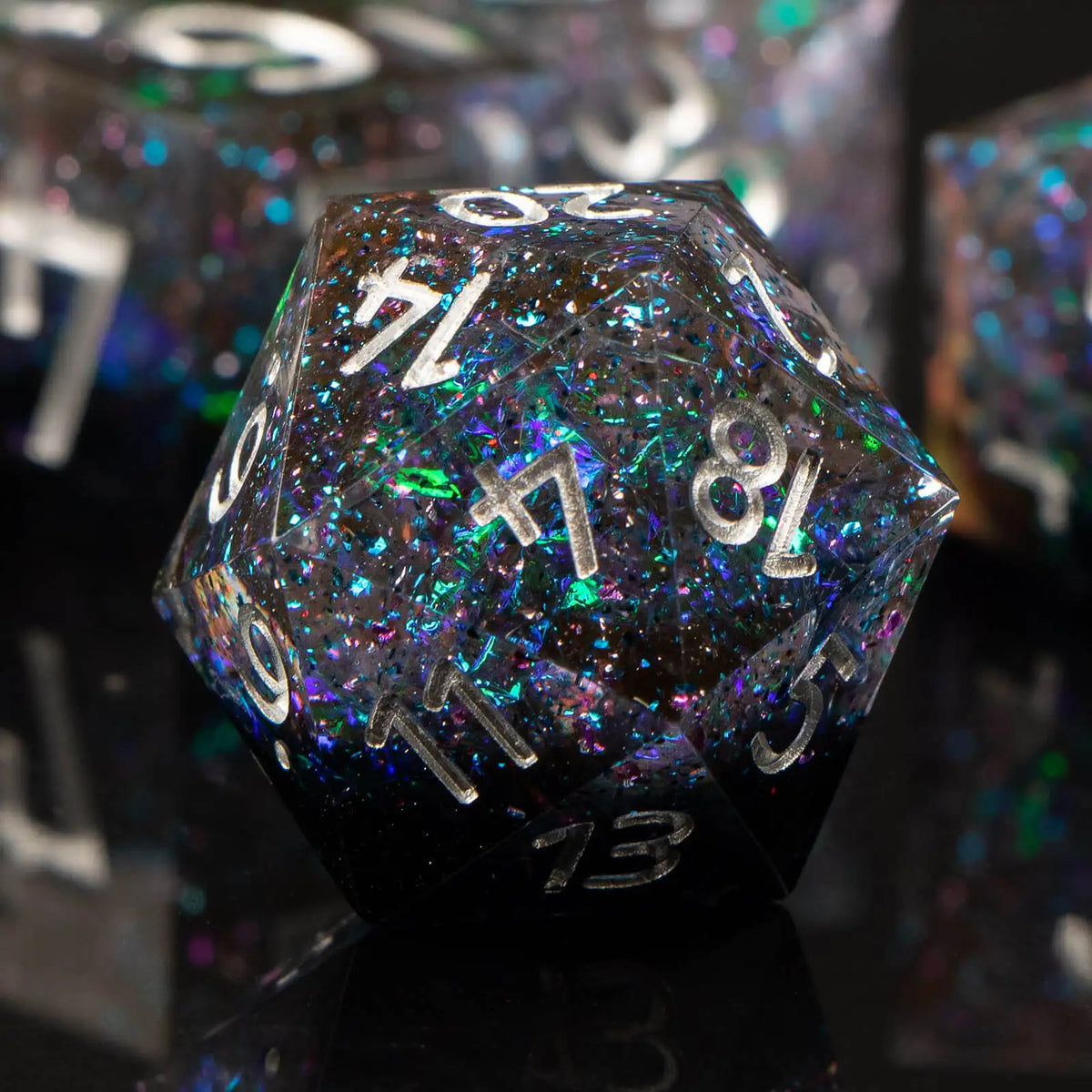 A close-up of a dark, iridescent resin polyhedral die with numbers visible on its faces.