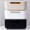 A stack of three white and black cable management boxes for organizing power strips and cords on a desk.
