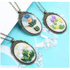 A set of three floral embroidery necklaces featuring various colored flowers on oval patches.