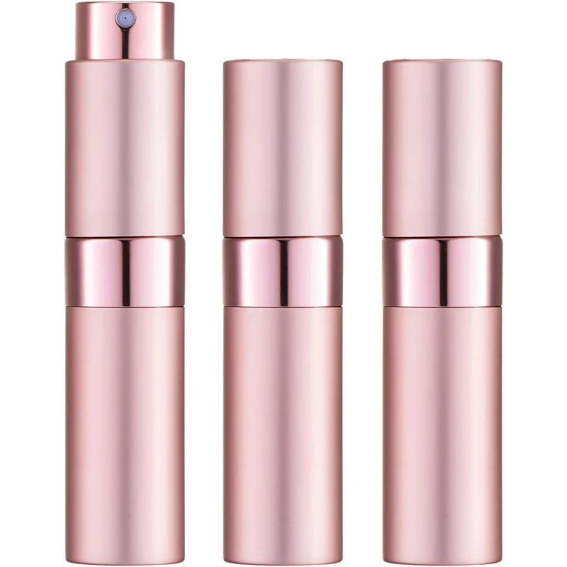 Un set de tres atomizadores de perfume de vidrio rosa en diseño cilíndrico.