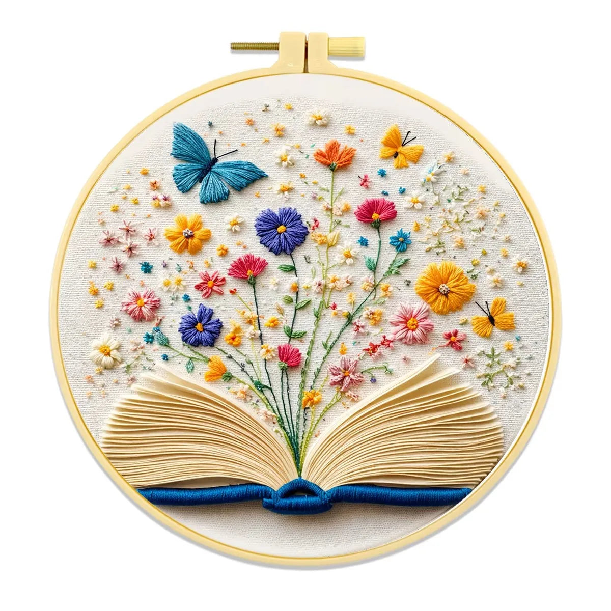 A round embroidery kit featuring a book design with floral elements and a gold-toned metal clasp.
