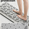 A gray non-slip bathroom rug with a pebble texture is shown being used on a bathroom floor.