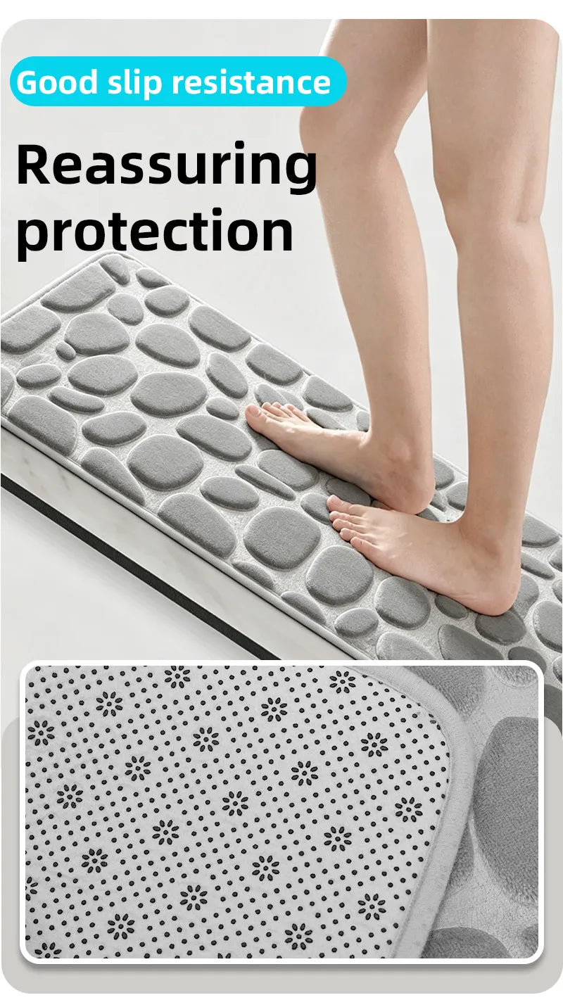 A gray non-slip bathroom rug with a pebble texture is shown being used on a bathroom floor.