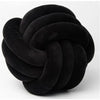 A round, black velvet throw pillow with a tightly knotted texture.