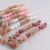 A collection of personalized silicone pacifier clips with baby names and various colors arranged on a white background.