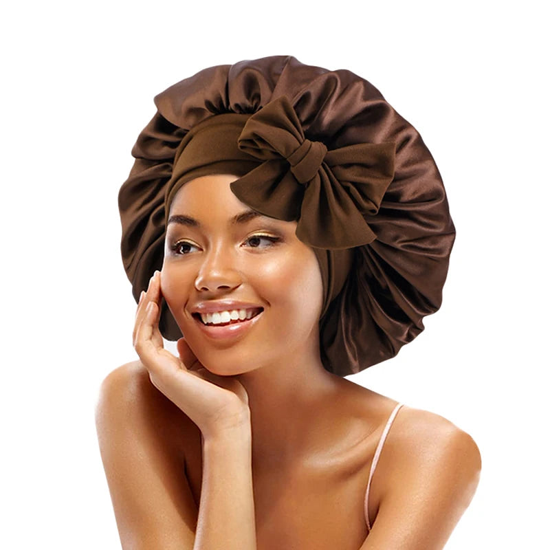 A woman wearing a dark brown satin sleeping bonnet with an adjustable tie.