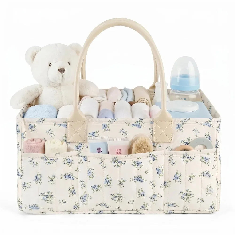 A beige floral diaper organizer bag featuring a teddy bear and multiple compartments for baby supplies.