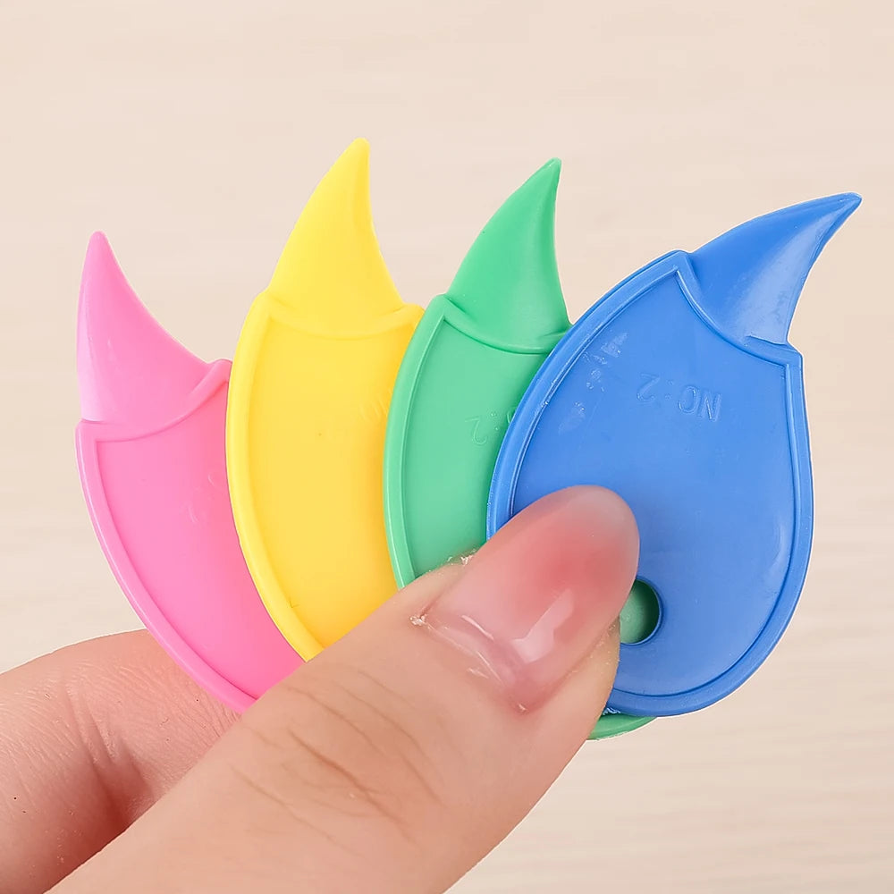 A hand holds a set of colorful plastic box cutters and letter openers in pink, yellow, and blue.