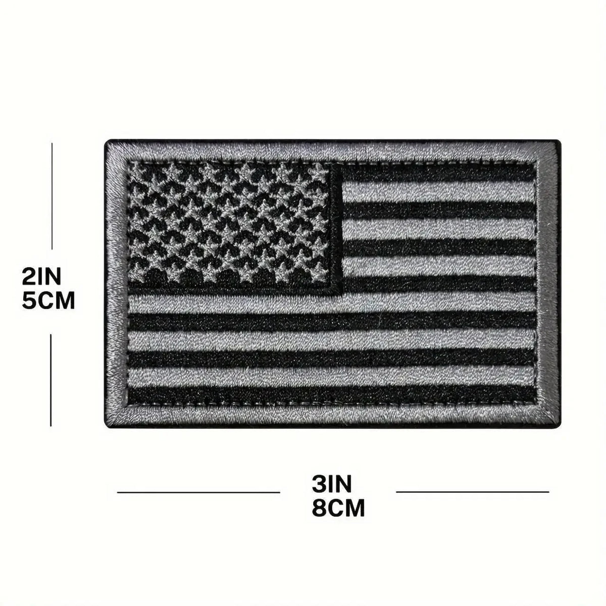 A rectangular patch featuring an embroidered American flag design with stars and stripes in black and gray.