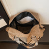 A tan leopard print duffle bag with adjustable straps resting on a dark surface.