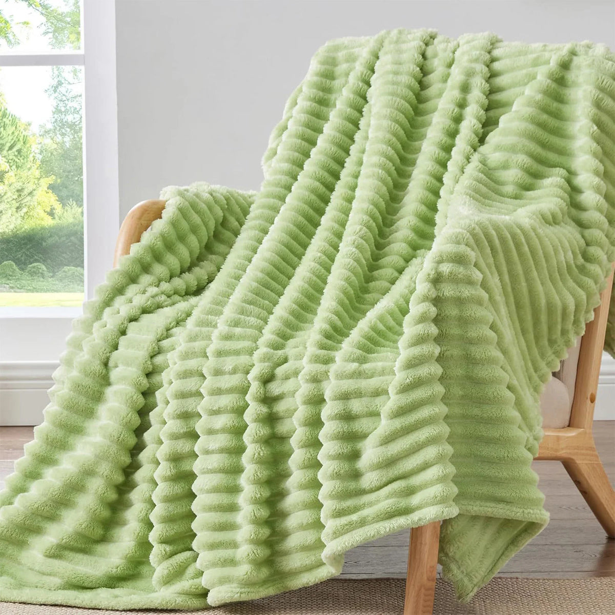 Una manta de franela verde claro y acanalada, colgada sobre una silla de madera.