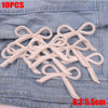 Ten embroidered light beige cartoon bow iron-on patches displayed on a denim fabric.