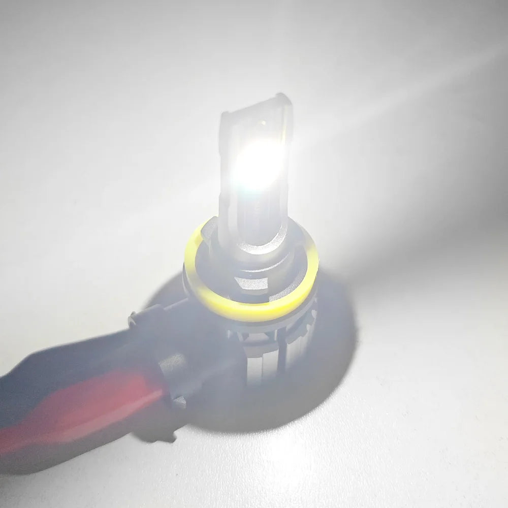 Nahaufnahme einer universellen LED-Nebelscheinwerferglühbirne mit gelbem Sockel und hellem Licht.