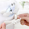A hand is using a curved veneer to organize and secure electrical wires and plugs.