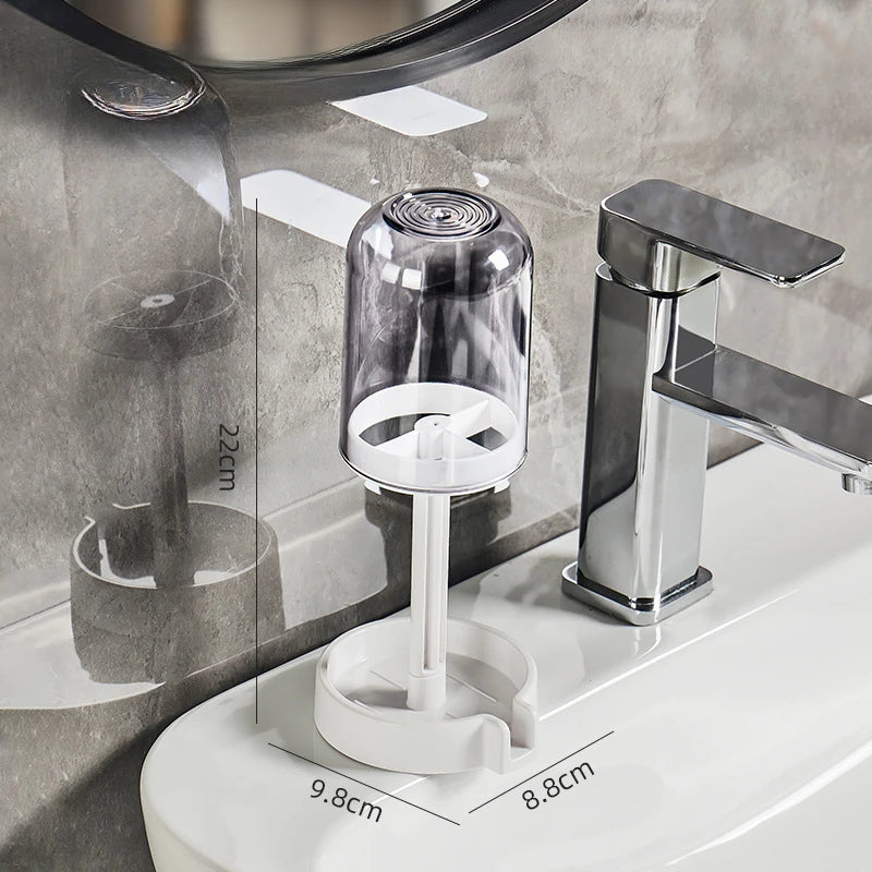 A modern chrome toothbrush holder with a dust cover and drainage system mounted on a white toilet tank.
