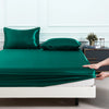 Leuchtend smaragdgrüne Satin-Bettwäsche-Set mit Bezugs-, Bett- und Kissenbezügen auf einem weißen Bett.