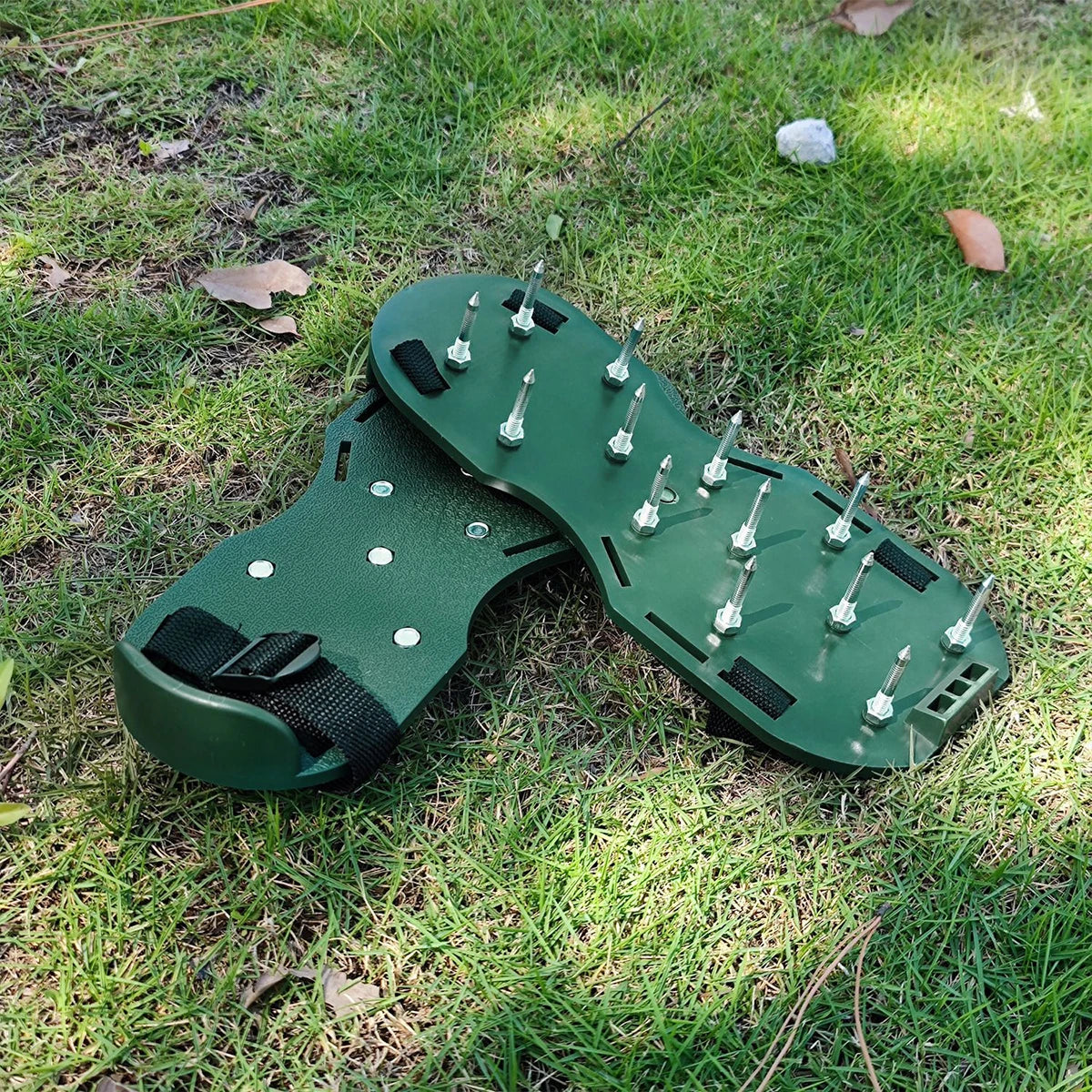 A pair of green adjustable lawn aerator shoes with heavy-duty spikes lying on green grass.