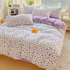 A purple and white floral duvet cover set with a leopard print pattern displayed on a bed.