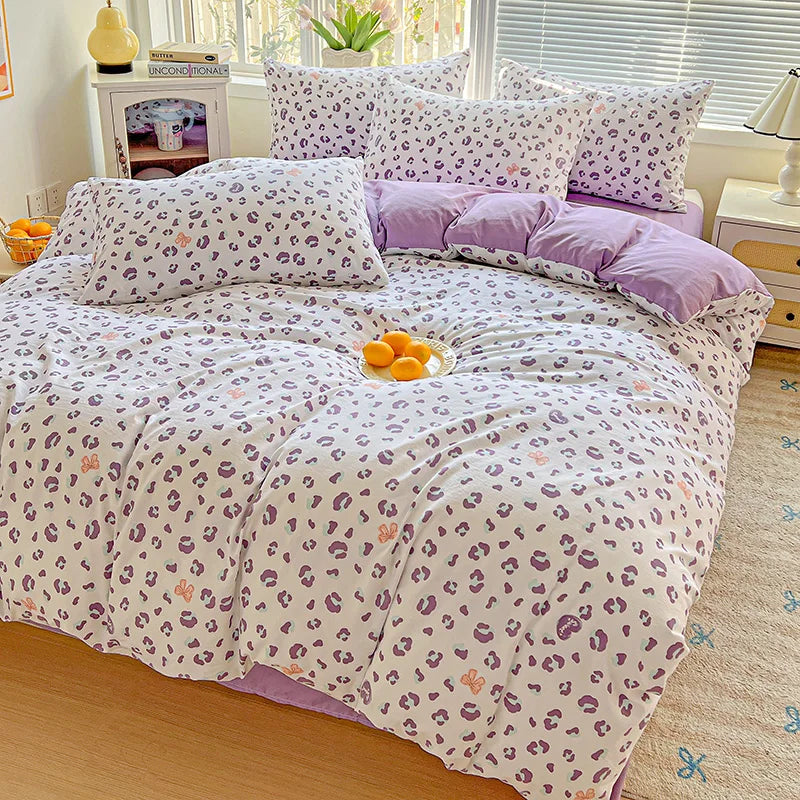 A purple and white floral duvet cover set with a leopard print pattern displayed on a bed.