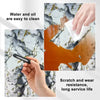 A hand cleans a marble surface with a white cloth, demonstrating the ease of cleaning for 3D marble peel-and-stick panels.