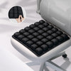 A black adjustable press-to-inflate seat cushion with a hand demonstrating its use, shown in an office chair context.