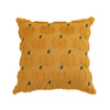 A square plush throw pillow covered in an orange fabric featuring a repeating pattern of small green pumpkins.