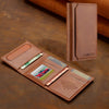 A brown leather magnetic wallet phone case with card slots and a kickstand resting on a dark surface.