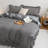 A plaid duvet cover set in black and white checks with matching pillowcases on a bed.