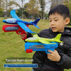 A boy holds a blue foam glider airplane and a red foam blaster, demonstrating the ejection foam aircraft toy set.