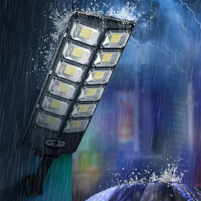 A rectangular solar garden light with multiple LED panels is shown against a dark, rainy background.