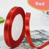 A roll of red satin ribbon with gold edges, used for crafts and gift wrapping.