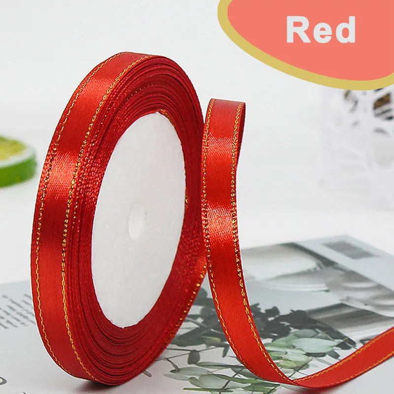 A roll of red satin ribbon with gold edges, used for crafts and gift wrapping.