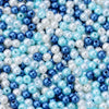 A close-up of round imitation pearl beads in various shades of blue and white scattered on a surface.